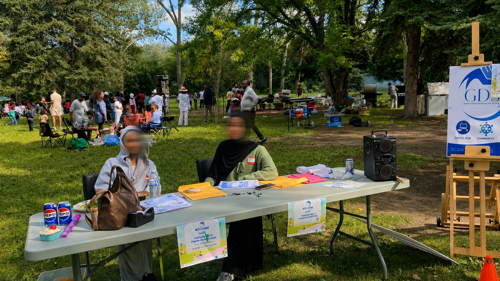 GDS volunteers welcoming guests at an outdoor community event, with faces privacy blurred